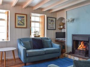 a living room with a blue couch and a fireplace at The Moorings in Staithes