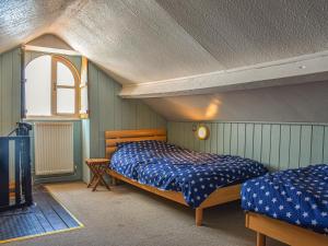 a bedroom with two beds and a tv in it at The Moorings in Staithes