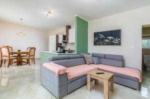 a living room with a blue couch and a table at Apartman Darija in Vodnjan