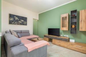 a living room with a couch and a flat screen tv at Apartman Darija in Vodnjan