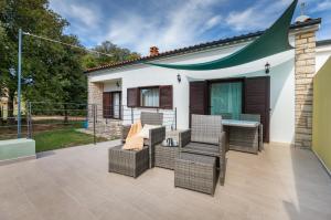 a patio with wicker chairs and a table at Apartman Darija in Vodnjan
