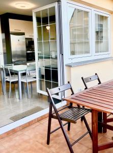 een patio met een tafel en stoelen en een keuken bij Apartamento Playa Blanca in Corcubión