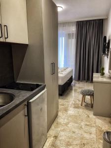 a kitchen with a sink and a room with a bed at MD APARTMENTS in Ulcinj