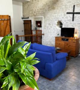 eine blaue Couch in einem Wohnzimmer mit einem Kreuz an der Wand in der Unterkunft Naturo-gites in Nieul-le-Virouil