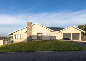 a large white house with a driveway at Seafront Retreat in Sandbaai in Hermanus