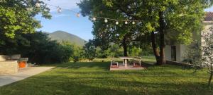 a picnic table in a park with mountains in the background at Getaway house Loko in Trebinje
