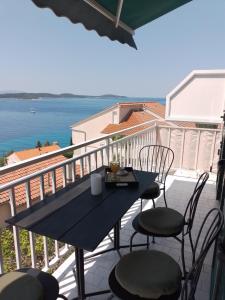 a table and chairs on a balcony with a view of the ocean at NatasaHvar in Hvar