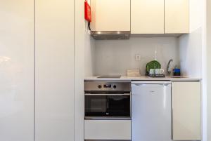 uma pequena cozinha com um fogão e um frigorífico em Urbana Homes by Home Sweet Home Aveiro em Aveiro