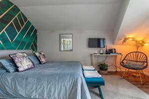 um quarto com uma cama grande e uma cadeira em Urbana Homes by Home Sweet Home Aveiro em Aveiro