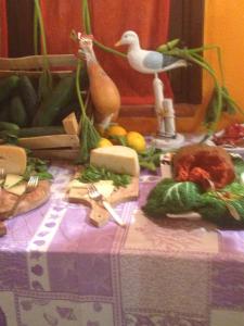 una mesa con un pájaro y verduras. en Villaggio Athragon, en Capo Vaticano