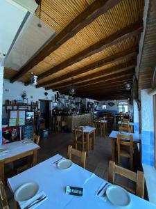 uma sala de jantar com mesas e cadeiras e um restaurante em Zé Inácio - Alojamento e Restaurante em Porto Covo