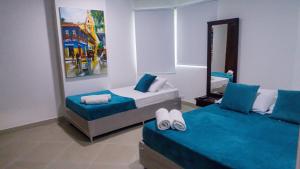 a bedroom with two beds and a mirror at 2B/2B Gorgeous Sunsets-Ocean View -Pool in Cartagena de Indias