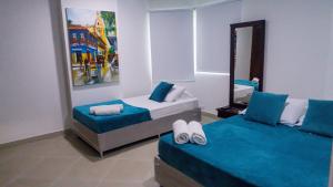 1 dormitorio con 2 camas y espejo en 2B/2B Gorgeous Sunsets-Ocean View -Pool, en Cartagena de Indias