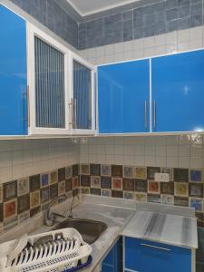 a kitchen with blue cabinets and a sink at Abeer Suites 3 basement in Hurghada