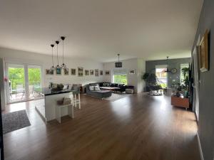 Villa Nature في سراييفو: غرفة معيشة مع أرضيات خشبية وغرفة معيشة مع أريكة