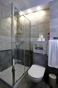 a bathroom with a toilet and a glass shower at Samodzielne 3-pokojowe mieszkanie blisko plaży in Ustka
