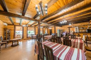 a dining room with tables and chairs and wooden ceilings at Сосновий Бір, Світязь in Svityazʼ