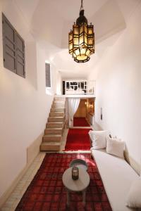 a living room with a white couch and a chandelier at Riad Les Hirondelles Boutique Hotel in Marrakech