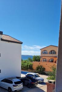 two cars parked in a parking lot in front of a building at Ni-Ka in Pag