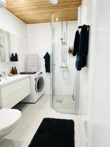 uma casa de banho com um chuveiro e uma máquina de lavar roupa em Uusi upea kaksio Tampereen ytimessä, pysäköinti, iso lasitettu parveke em Tampere