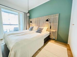 - une chambre avec un grand lit blanc et une fenêtre dans l'établissement Uusi upea kaksio Tampereen ytimessä, pysäköinti, iso lasitettu parveke, à Tampere