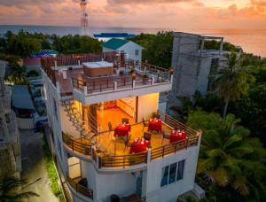una vista sul tetto di un edificio con sedie rosse sul balcone di Vilu Thari Inn Maldives a Mahibadhoo