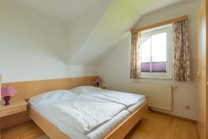 a bedroom with a white bed and a window at Appartment Isabelle Sky in Presseggersee