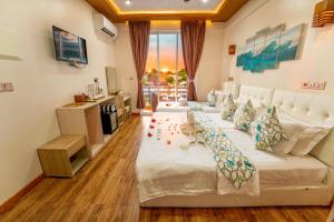 a hotel room with two beds and a desk at Vilu Thari Inn Maldives in Mahibadhoo