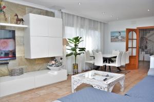 a living room with a table and white furniture at VILLA SOFIA CALELLA in Calella