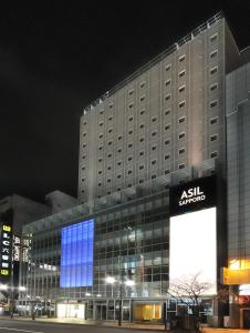 a building with a lit up sign in front of it at Hotel Route-Inn Sapporo Chuo in Sapporo