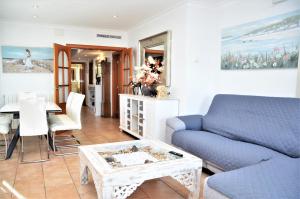 a living room with a blue couch and a table at VILLA SOFIA CALELLA in Calella