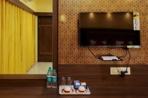 Habitación con TV y mesa con bebidas. en sri balaji grand hotel, en Kumbakonam