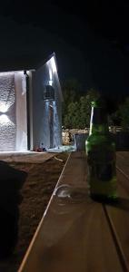 波德戈里察的住宿－Piper's house，夜晚坐在桌子上的绿瓶