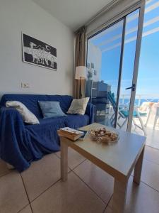 a living room with a blue couch and a table at Comfortable Lucy apartment with amazing sea-view in Puerto del Carmen