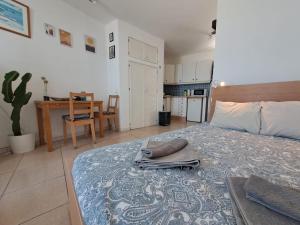a bedroom with a bed with a table and a kitchen at Comfortable Lucy apartment with amazing sea-view in Puerto del Carmen