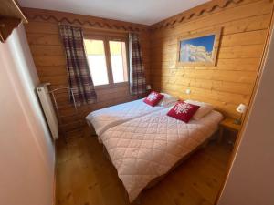 een slaapkamer met een bed met rode kussens erop bij Tignes-8-10 personnes-4 chambres-parking in Tignes