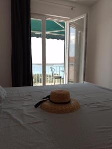 a straw hat is sitting on top of a bed at NatasaHvar in Hvar