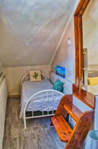a small bedroom with a bed and a desk at City Views Spacious Mezzanine Apartments in Willemstad