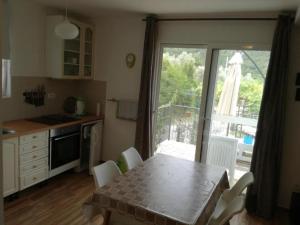 a kitchen with a table with chairs and a window at Apartmani Stanislav in Petrovac na Moru +7 photos