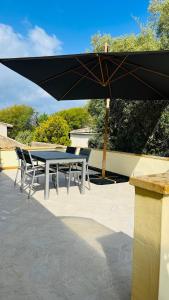 een tafel en stoelen onder een parasol op een patio bij Casa Virginia in Maracalagonis