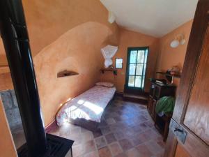 um quarto com uma cama no canto de um quarto em Old ceramic factory close to Unesco itineraries em Sorano