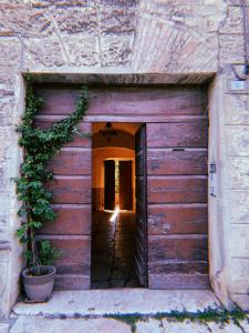 uma porta de garagem de madeira num edifício com uma planta em Claves Claustri - Camere in appartamento storico em Sarteano