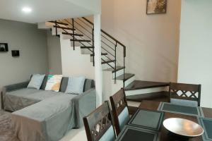 a living room with a couch and a spiral staircase at Renovated - City Center - Pool Access - 2 A/Cs in Cebu City