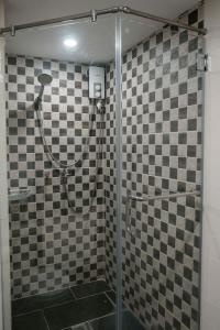 a shower in a bathroom with checkered tiles at Renovated - City Center - Pool Access - 2 A/Cs in Cebu City