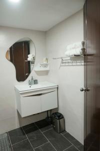 a white bathroom with a sink and a mirror at Renovated - City Center - Pool Access - 2 A/Cs in Cebu City
