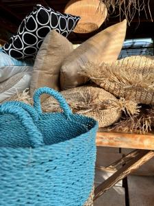 een blauwe mand bovenop een tafel met kussens bij Omala Village Gili Air in Gili Air