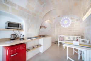 eine Küche mit einem roten Kühlschrank und einem Tisch in der Unterkunft WePuglia - Al Castello di AMEC - Apt Emanuela in Monopoli