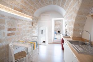 eine Küche mit einem Waschbecken und einer Steinmauer in der Unterkunft WePuglia - Al Castello di AMEC - Apt Emanuela in Monopoli