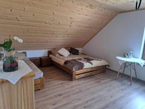 a bedroom with a bed and a wooden ceiling at Siedlisko Magiczne Cimanie in Cimanie