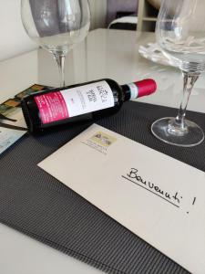 a bottle of wine sitting on a table with glasses at Alba Langhe Apartment in Alba